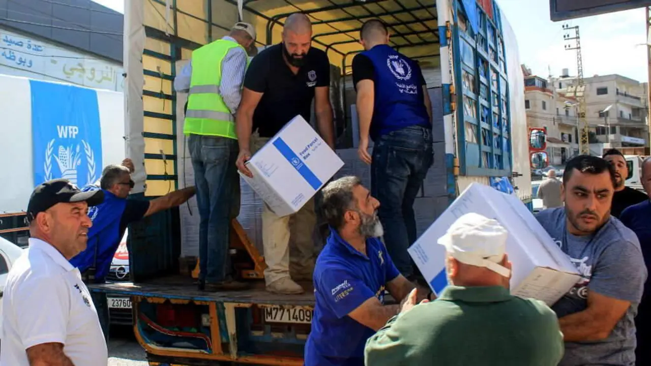 Persoal e voluntarios do Programa Mundial de Alimentos das Naci&oacute;ns Unidas descargan paquetes de alimentos na aldea de Qliyaa, no sur do L&iacute;bano. (Foto: Str- / dpa)