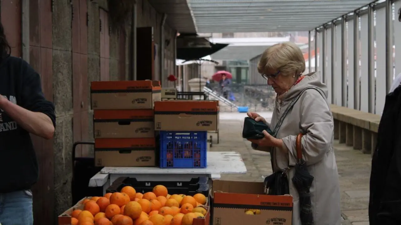 Unha muller paga a s&uacute;a compra no mercado de Abastos de Santiago de Compostela. (Foto: Clara Xanthina)