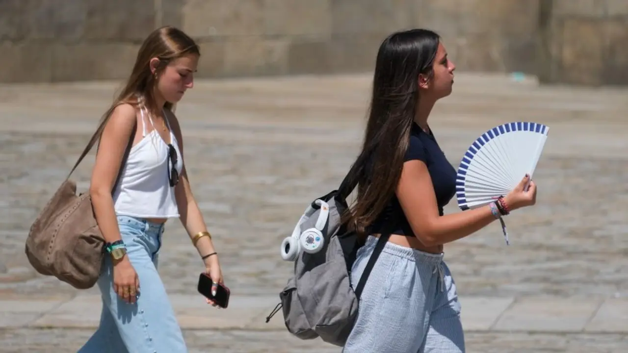 D&uacute;as mullerres procurando combater a calor na praza do Obradoiro de Compostela. (Foto: Arxina)