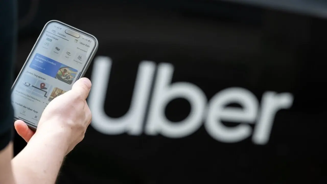 Un home ante un veh&iacute;culo da multinacional Uber. (Foto Sebastian Gollnow dpa)