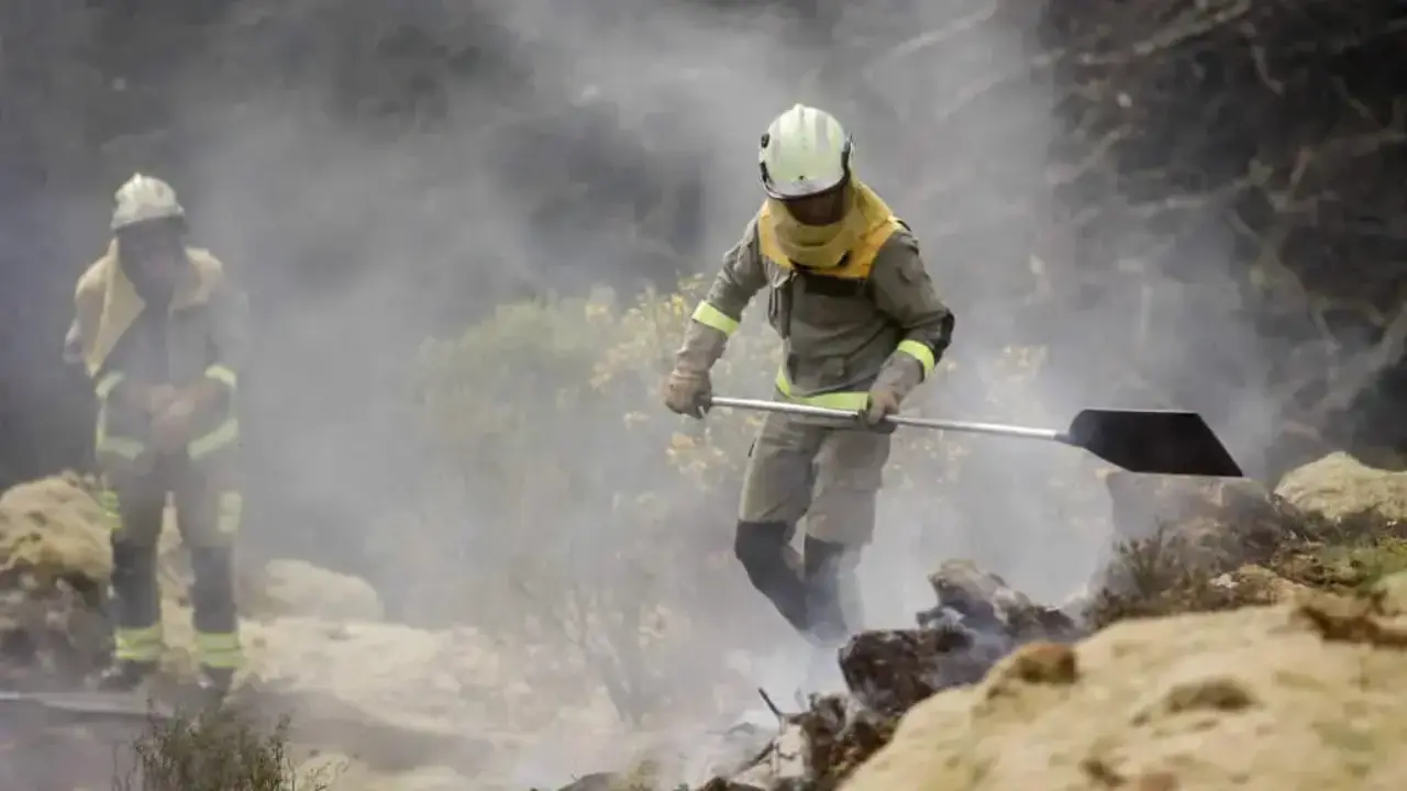 Dous brigadistas forestais traballan para extinguir as lapas dun incendio forestal. (Foto: Carlos Castro / Europa Press