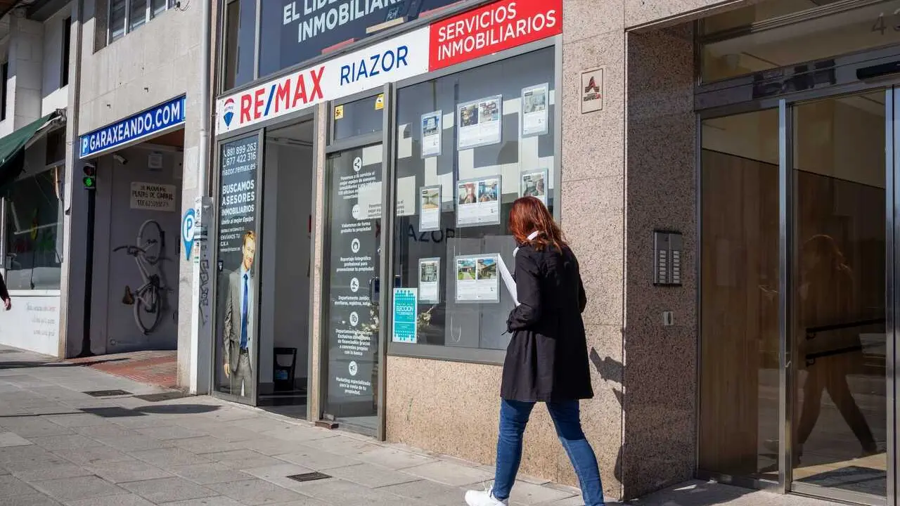 Unha persoa cami&ntilde;ando perto dunha inmobiliaria en Compostela. (Foto: Alma Alonso)