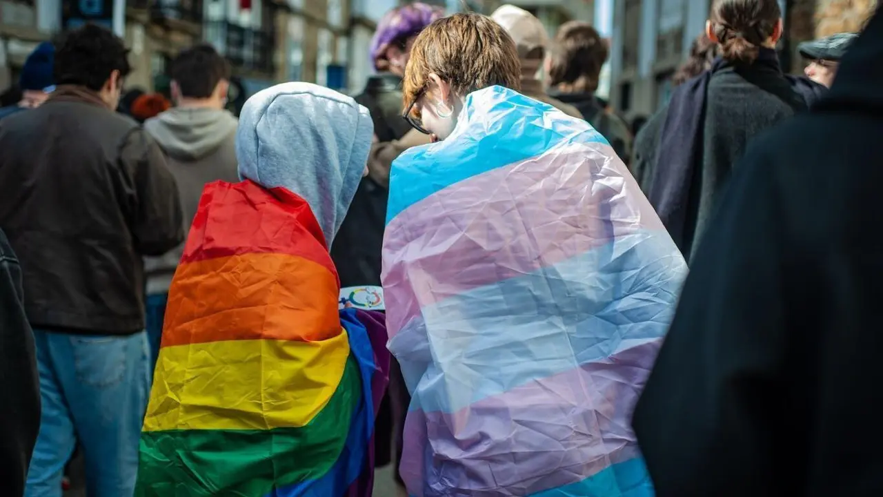 D&uacute;as persoas coa bandeira LGBTI+ e a bandeira trans na manifestaci&oacute;n pola visibilidade trans o 31 de marzo en Compostela. (Foto Arelas)