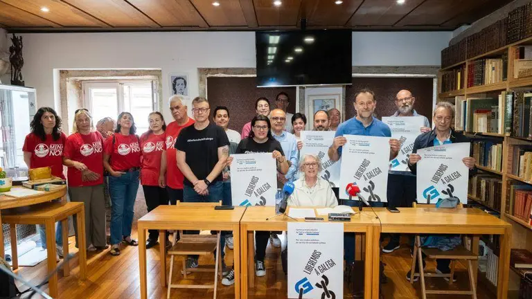A xornalista Tareixa Navaza, no centro, portavoz da plataforma que impulsa a ILP, durante a comparecencia. (Foto: Arxina)
