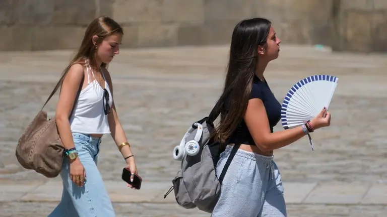 D&uacute;as mullerres procurando combater a calor na praza do Obradoiro de Compostela. (Foto: Arxina)